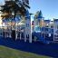Winter Mansion themed playground with blue and white castle structures, slides, and climbing element