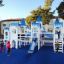 Children playing on the Winter Mansion playground structure with blue and white castle-like towers a
