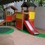 Knight's Castle playhouse with slide in a playground
