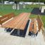 Outdoor Table & Bench Steel Construction set in a recreation area with grass and playground equipmen