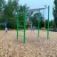 Outdoor playground equipment Monkey Bar with green frame and hanging rings in a park setting.