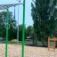 Outdoor Monkey Bar structure with gymnastic rings in a park.