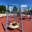 Copernicus steel structure playground equipment with climbing nets and round swing on a sunny day.