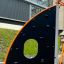 Copernicus steel structure - black climbing wall with orange frame on playground.
