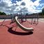 Copernicus steel structure playground with slide and climbing elements on red surface