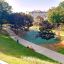 Orion steel structure on a playground surrounded by trees and people enjoying the park.