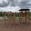 Meru playground set with slide and climbing frame in a park.