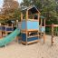 Outdoor Tower playhouse with slide in a playground.'