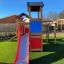 Tower playhouse with slide in a backyard playground