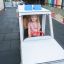 Child playing in an Ambulance toy at outdoor playground.