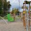 El Dorado wooden playhouse with climbing elements and green accents in a playground setting.