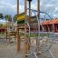 El Dorado wooden playhouse with climbing structures and slide.