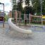 El Dorado wooden playhouse with slide and climbing structures in a playground