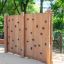 Outdoor wooden Climbing Wall with hand grips in a park setting.