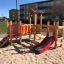 Wooden Fortress playhouse with slide on a playground.