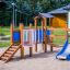 Fortress playhouse with slide and climbing area in playground.