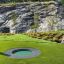 Round trampoline (80 cm) installed in a green landscape with rocky background.
