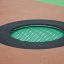 Round trampoline (100 cm) embedded in playground surface with black safety padding and green jumping