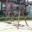 Double Swing in a playground with apartment buildings in the background.
