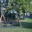 Double Swing playground set with tire and infant swings in a park.