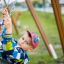 Boy playing on Double Swing playground equipment.