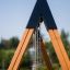 Wooden A-frame structure of the Double Swing with chains hanging down.
