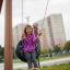 A girl smiling while swinging on a Double Swing playground equipment.