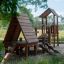 Galapagos wooden playhouse with slide in a park setting.