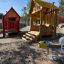 Bee rocking spring rider in a playground with wooden playhouses