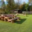 Wooden playground structures named Stairs on artificial turf in an outdoor park.