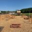 Stairs playground equipment in an outdoor setting with various wooden structures for children to pla