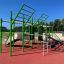 Outdoor Grandis Training Set with green metal structure and various workout stations on a red rubber