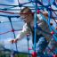 Child climbing on Autan climbing net playground equipment on a sunny day