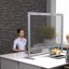 Glass partition between two people working at desks.