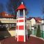 Lighthouse single playhouse, climbing net - tall red and white striped play tower outdoors