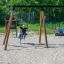 Children playing on Blackboard 156 cm swing set in a sandy playground.
