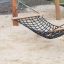 Triple Hammock playground equipment on sandy surface.