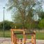 Trim trail wooden playground obstacle for children in outdoor sandy play area.