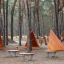 Tipi Nature wooden house playground equipment in forest setting with three wooden triangular playhou