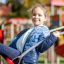 Child enjoying the Nature Double Swing 5m at the playground.