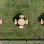 Round table & benches set on grass, top view.