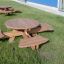 Round table & benches placed on a grassy area in front of a building.