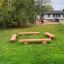 Robinia bench set in a grassy playground area.