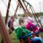 Children playing on a 2+2 multiple swing set.