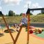 Boy playing on 2+2 multiple swing in a playground.