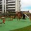 Alt text: Dog Rocking spring rider on modern playground with slides and swings.