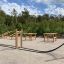 Outdoor fitness area with Battle Rope Workout Set and other workout equipment surrounded by greenery