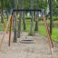 Bird Nest Single Swing (BNS 120 cm) installed in a wooded playground.