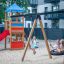 Children playing on Bird Nest Swing with Tower (BNS 120 cm) with a single slide in a playground.