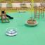 Mini Play II playhouse with slide on a playground with green safety surface and climbing structure n